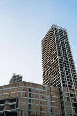 Facade of residential or business multi-story building skyscraper under construction. Incomplete or...