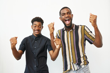 Two African American men celebrating with joy, showing excitement and happiness in their...