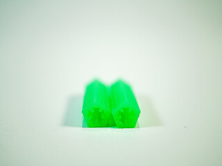 Close-up of two vibrant green 3D printed hexagonal objects, demonstrating additive manufacturing...