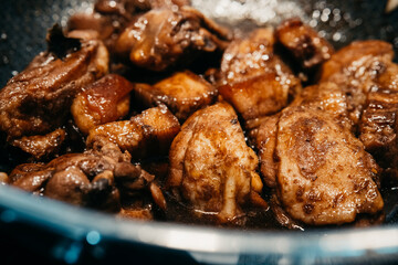 Savory chicken pork adobo simmering in a pan with rich sauce and spices. 