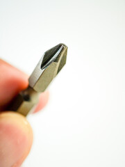 Close up of a metal Phillips head screwdriver bit demonstrates precision engineering for fastening screws and hardware.