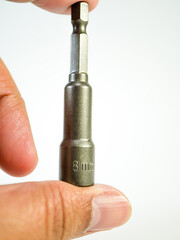 Close up shot displays a metallic socket wrench bit being held, a common tool used for mechanical...