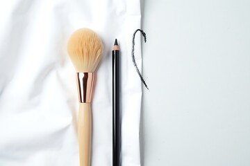 Makeup brush and eyeliner pencil on white background for beauty products and cosmetic accessories flatlay 