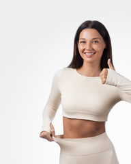 Happy Sport Woman Showing Weight Loss In Loose Leggings With Thumbs Up