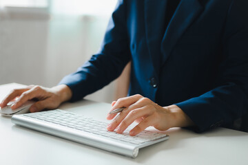 Woman's hands are using a computer keyboard and mouse to Searching for information. business working woman data search technology	