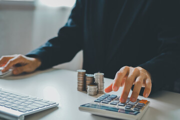 young woman using calculator calculating monthly home expenses, taxes, bank account balance and credit card bills payment, concept saving money.	