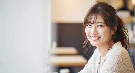 カフェでこちらを見て微笑む若い女性