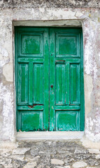 Fototapeta premium Old, worn, green-painted wooden doors. Architectural element.