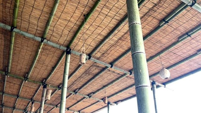 青い竹とすだれでつくられた海の家の天井に吊られ風に揺れる手作りの竹のランタン_30p