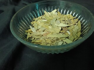 dried Senna leaves close up photo on black background, commonly used in herbal medicine,...