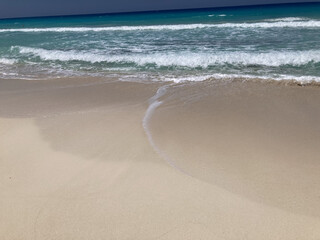 shoreline with peaceful blue waves and soft sand