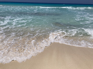 foamy ocean waves on white sand