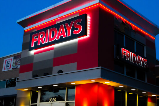 An illuminated TGI Friday's building in the evening isolated against the night sky in Columbia, Missouri on July 6, 2025. For Editorial Use.