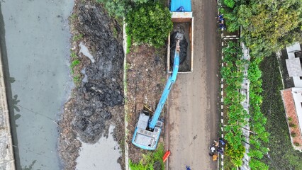 image from above of heavy equipment excavator dredging mud from rivers and lakes