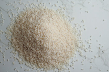 Rice grains scattered on a white surface