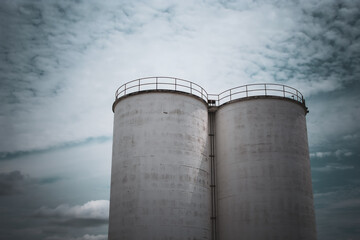 large concrete cement silos isolated against a beautiful sky abstract background