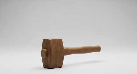 A Single Wooden Mallet Resting on a Soft Gray Background, Showcasing Craftsmanship and Design