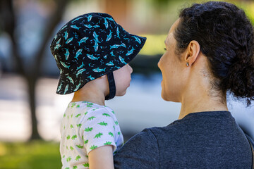 Mother Holding Boy with a Dinosaur Shirt Outdoors