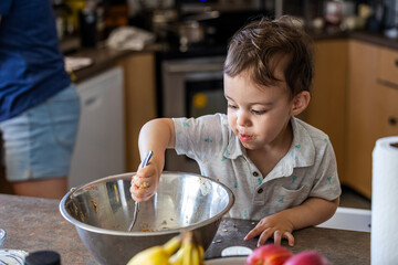 Young Boy Toddler Mixing Ingredients While Cooking in a Home Kitchen