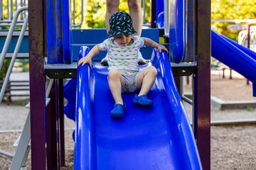 Toddler Playing on a Slide Outdoors in a Playground, Vancouver, BC, Canada