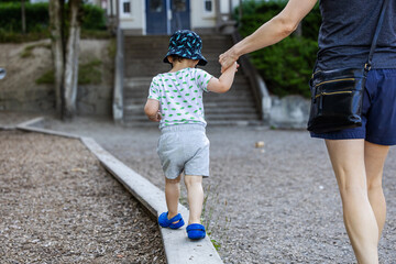 Parent Assisting Toddler Walking on Beam in Vancouver Playground, BC