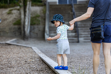 Boy Toddler Walking on Border in Vancouver Playground, Holding Parent's Hand