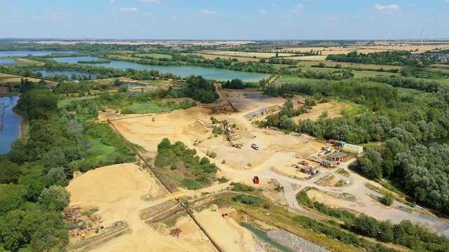 Aerial drone perspective of a quarry mining area with heavy machinery and aggregates minerals extraction in rural landscape near Little Paxton England UK