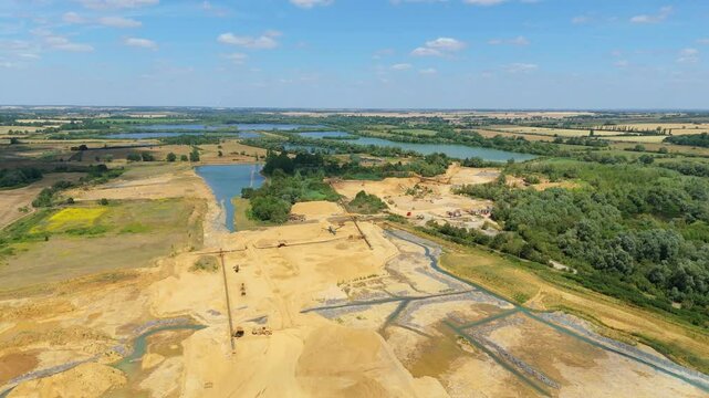 Aerial drone perspective of a quarry mining area with heavy machinery and aggregates minerals extraction in rural landscape near Little Paxton England UK
