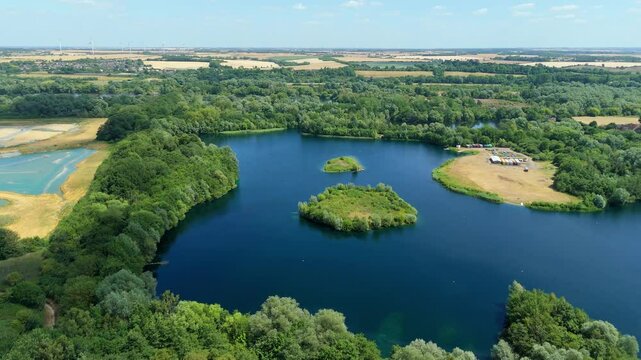 Aerial drone shot beautiful blue lakes and lush greenery aqua water wetland reserve Summers day sunny near Little Paxton England UK