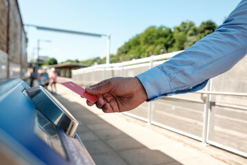 Businessman using credit card to pay for train ticket at outdoor terminal