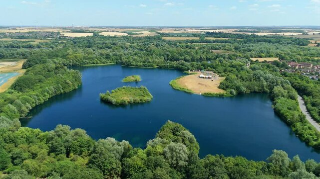 Aerial drone shot beautiful blue lakes and lush greenery aqua water wetland reserve Summers day sunny near Little Paxton England UK
