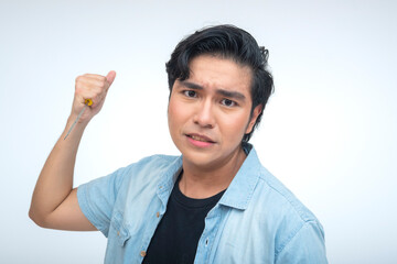 Gen Z Filipino man acts enraged and aggressive in studio while raising a screwdriver like a weapon,...