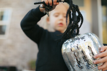 Toddler playing with shiny halloween decoration and spider wand