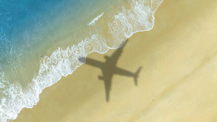 Aerial view of shadow passenger plane silhouette and sandy beach blue sea with waves at sea beach summer vacation sea travel concept	
