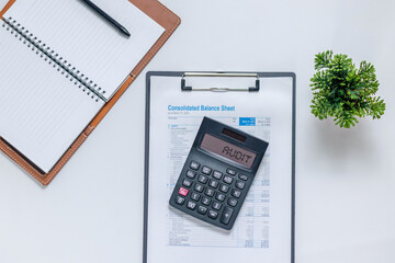 Notebook, pen, calculator, and  financial data paperwork on desk. Financial audit concept.
