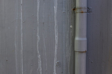 Textured Exterior Wall Featuring Discoloration From Water Runoff Near Plumbing Pipe
