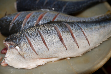 Cleaned raw fish on a white plate, showcasing freshness and culinary preparation