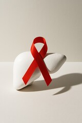 A symbolic representation of health awareness featuring a red ribbon on a stylized liver. Ideal for promoting liver disease awareness and health initiatives.
