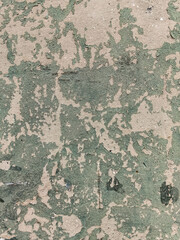 abstract texture of old beige wall with peeling gray-green paint

