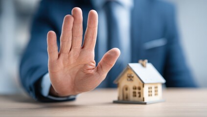 Businessman rejecting a house model (1)