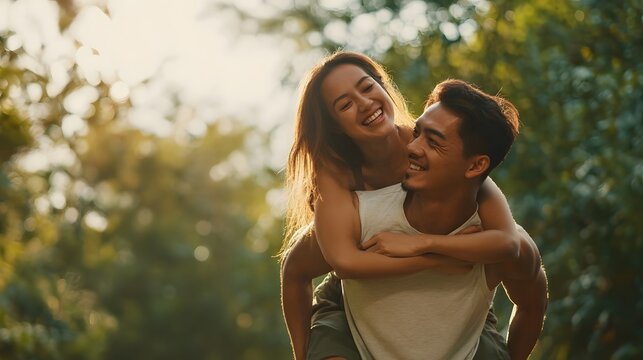 Fit couple sharing a playful piggyback ride while enjoying the outdoors smiling and supporting each other during a wellness workout or training session - Powered by Adobe