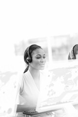 Black and white diverse business people using phone headsets in office