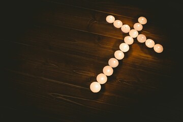 Candles in shape of cross on table