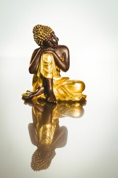 Buddha statue with reflection on table