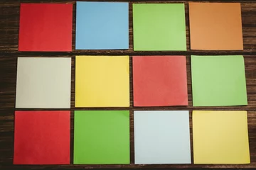 Gardinen Neatly arranged colorful papers on wooden floor © vectorfusionart