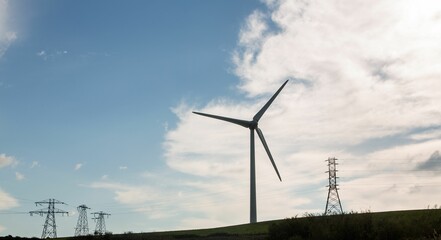 Windmill spinning over a green field