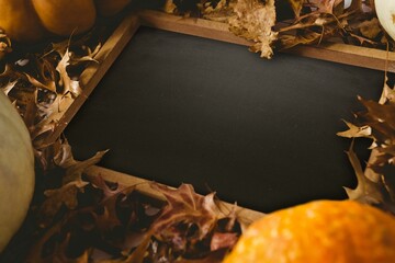 Black screen surrounded by brown leaf and pumpkin