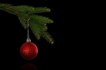 Flat design pine branch is extending, holding red glitter bauble against black backdrop, copy space
