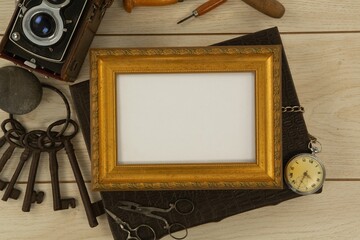 Photo frame, clock, keys, camera on wooden table
