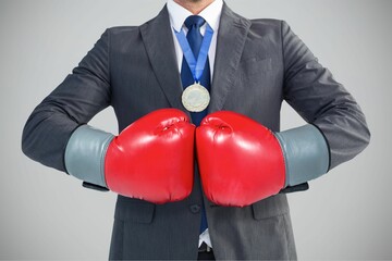 Midsection of businessman in red boxing gloves